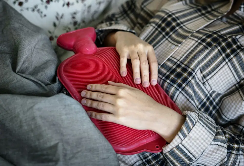 person holding red hot water bag