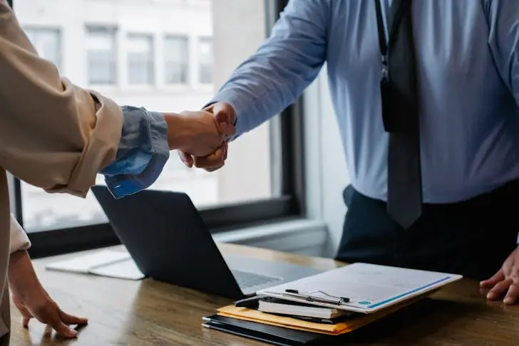 Life changes - Colleagues shaking hands in office.