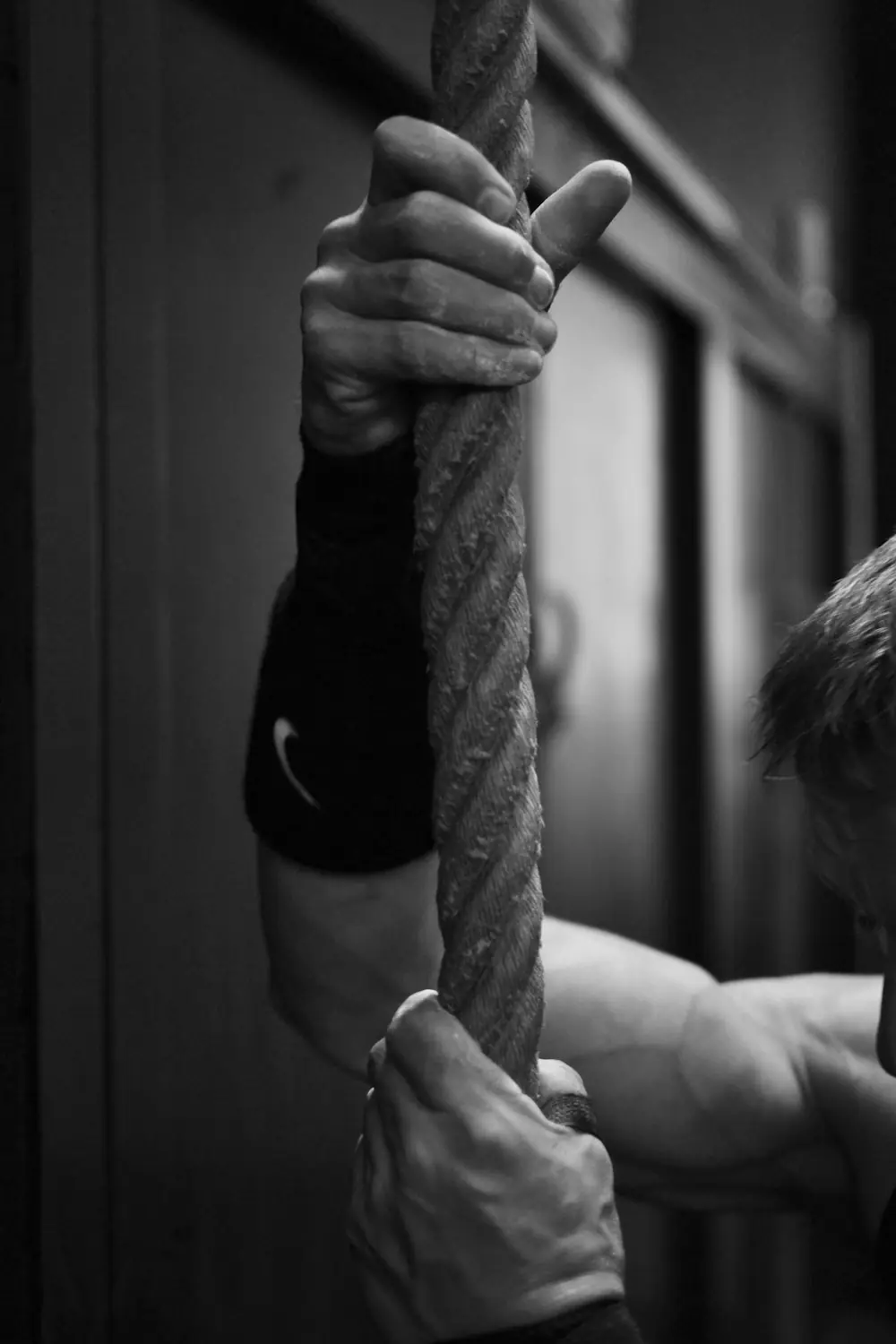 gray scale photo of man holding rope