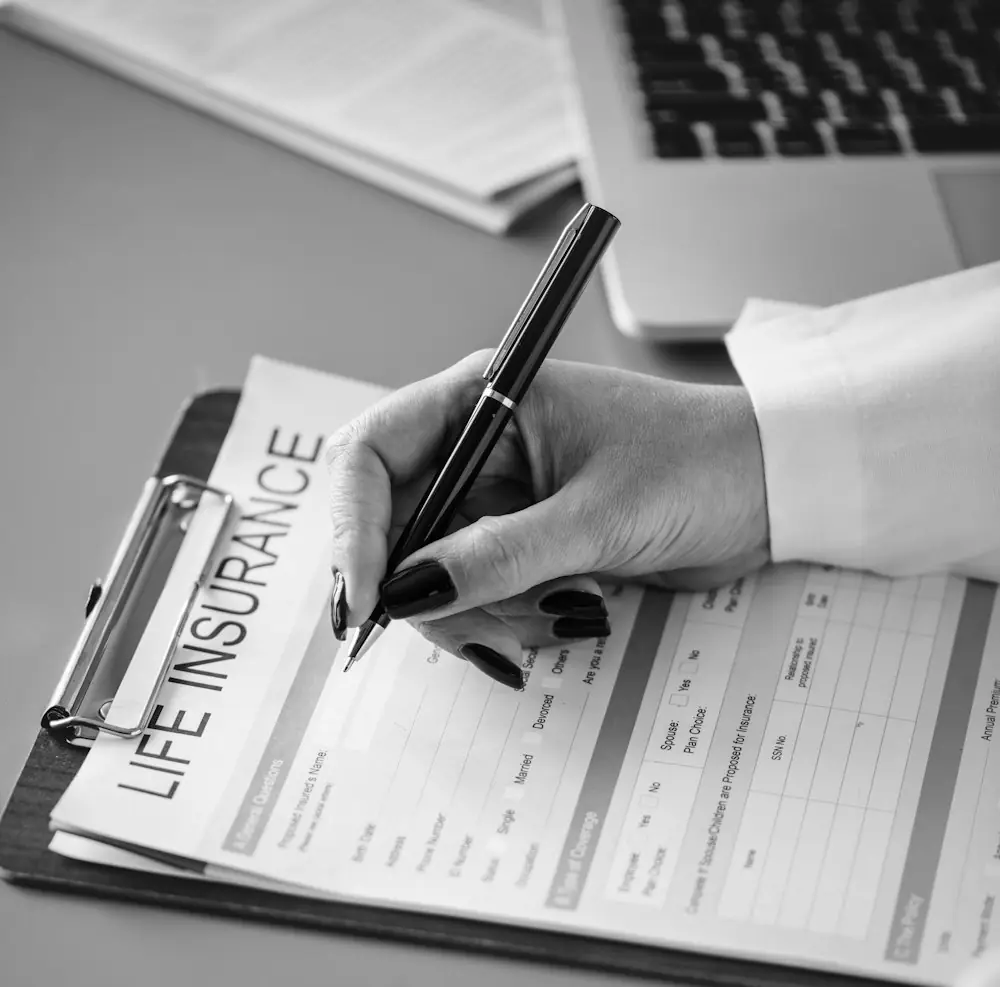 grayscale photography of person holding pen